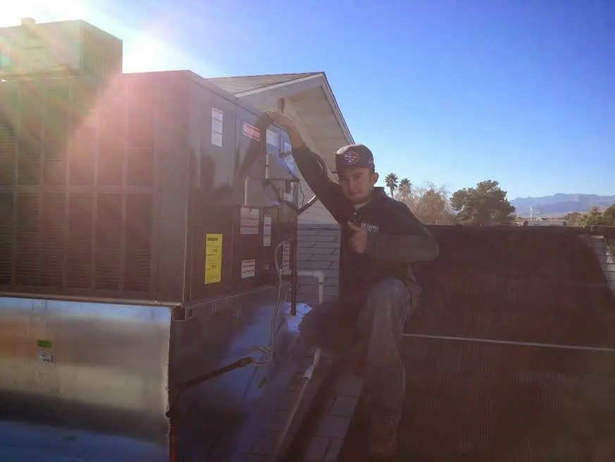 HVAC technician performing Air Duct Cleaning on a rooftop unit in Northport